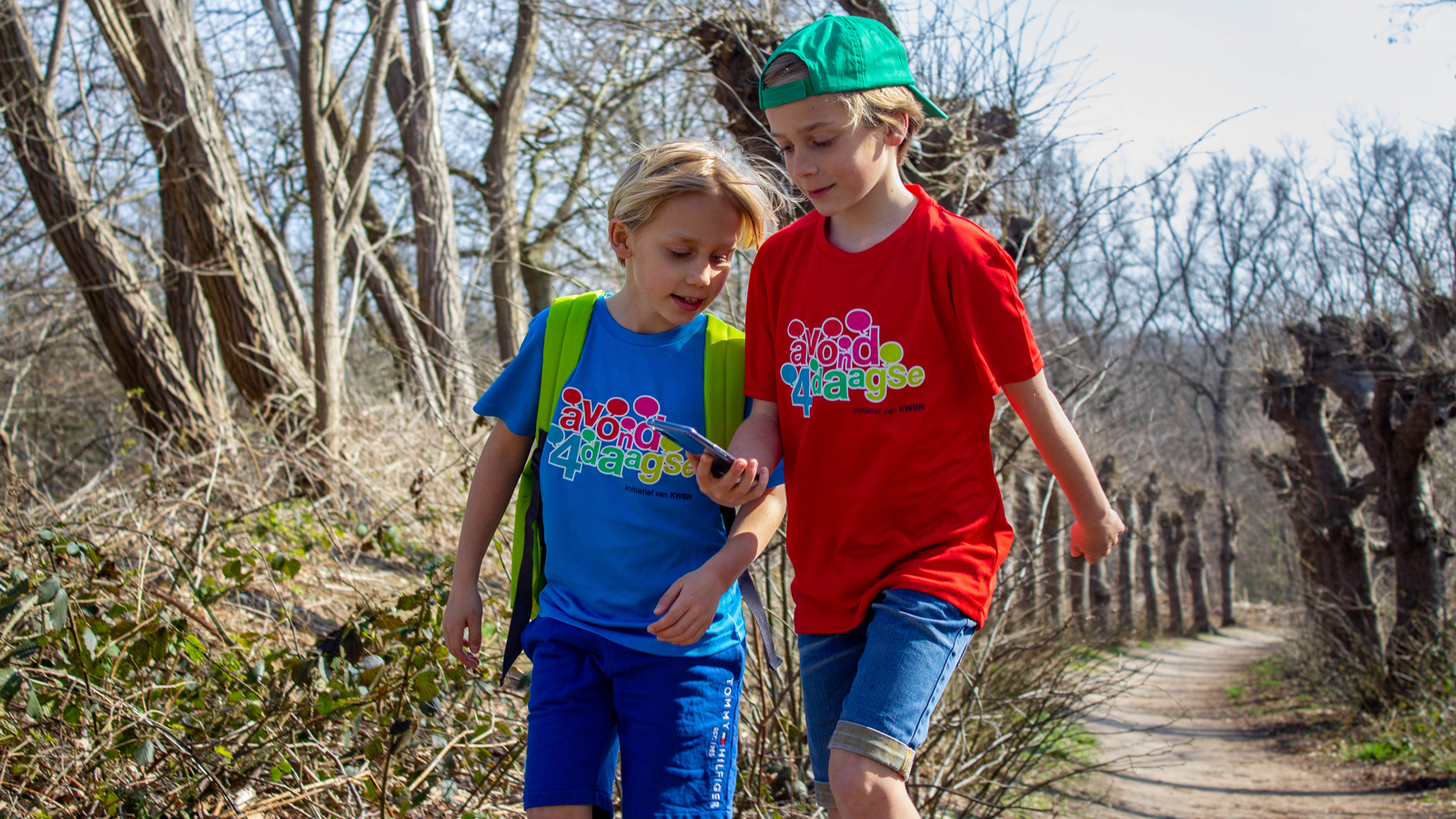 Twee jongens met Avond4daagse t-shirt aan en mobiel in de hand