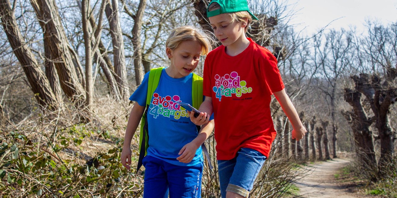 Twee jongens met Avond4daagse t-shirt aan en mobiel in de hand