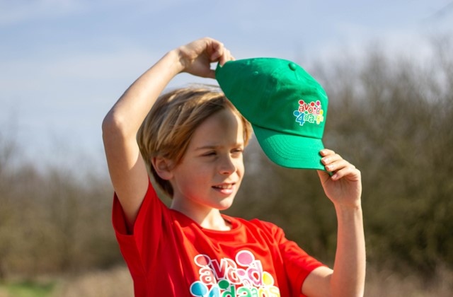 Jongen met Avond4daagse shirt zet Avond4daagse pet op