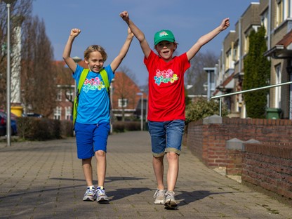 Twee jongens zwaaiend gekleed in een Avond4daagse shirt en pet